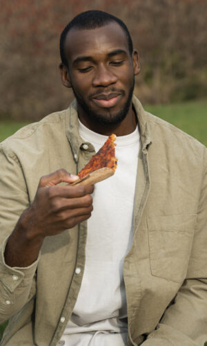 vue-de-face-homme-tenant-une-tranche-de-pizza